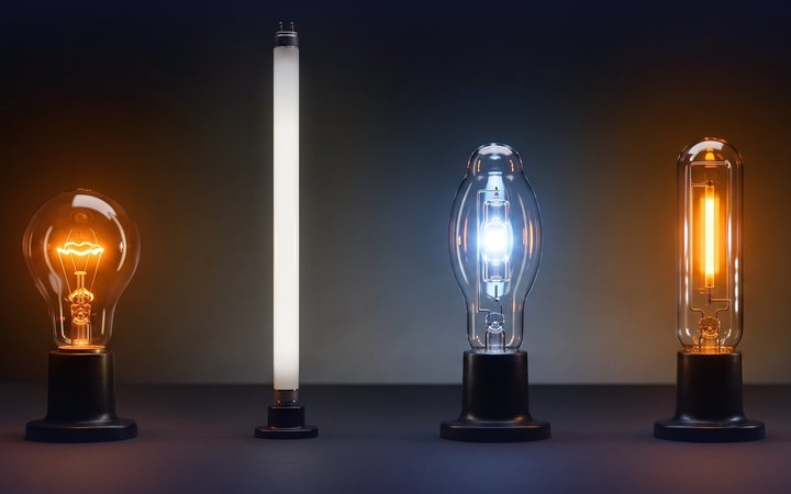 Four conventional lamps glowing in a row: an incandescent bulb, a fluorescent tube, a metal halide lamp and a sodium lamp.