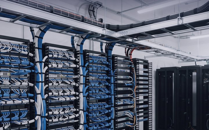 A floor distributor: racks dressed with blue and white structured cabling, fed from overhead cable trays.